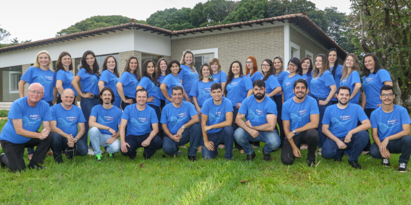Equipe da Inova Unicamp reunida em frente à sede na fazenda argentina, todos com a camiseta azul de comemoração dos 15 anos da Agência