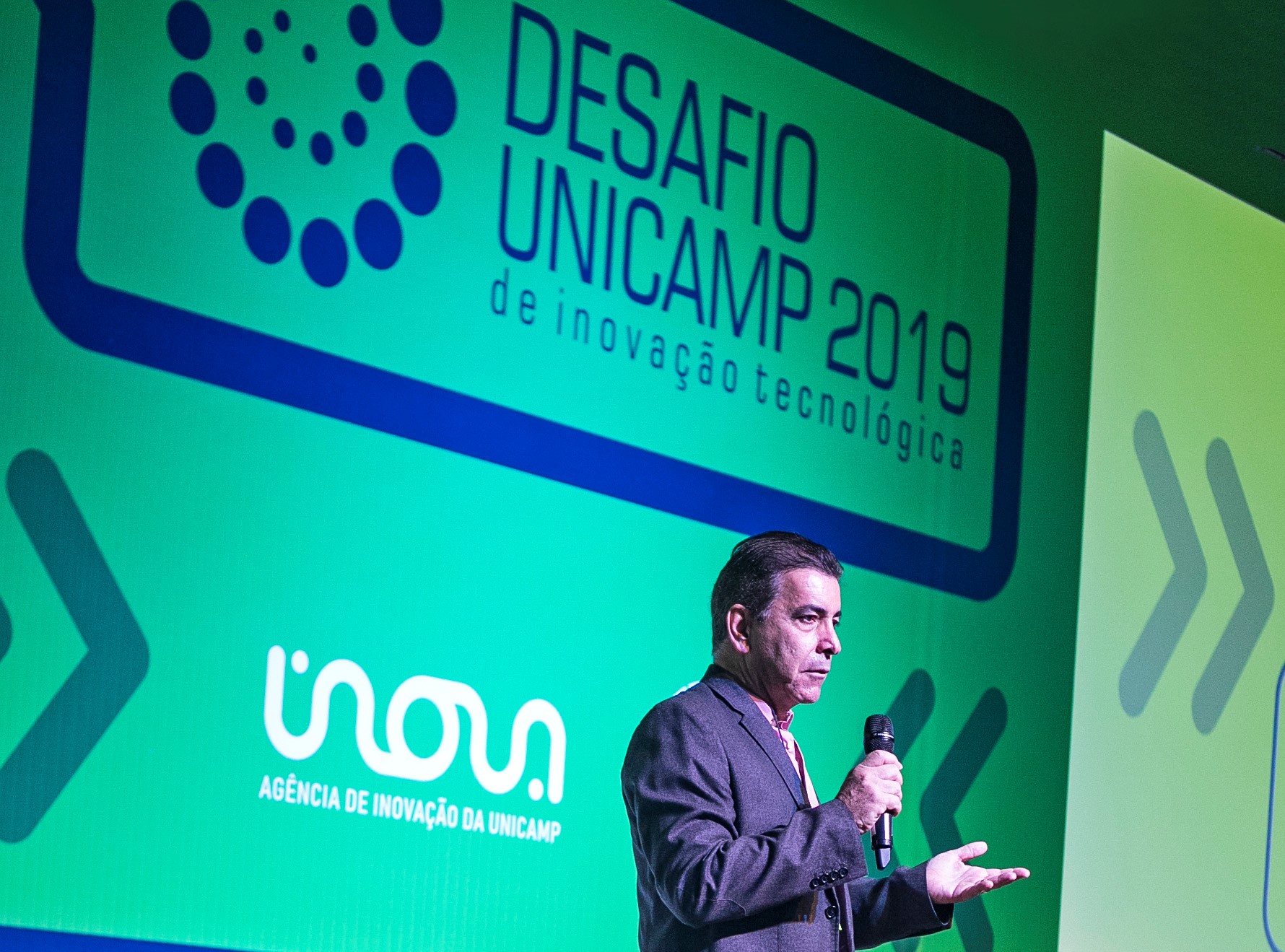 Prof. Newton Frateschi abre o Desafio Unicamp 2019. O fundo do evento é verde com logo em azul.