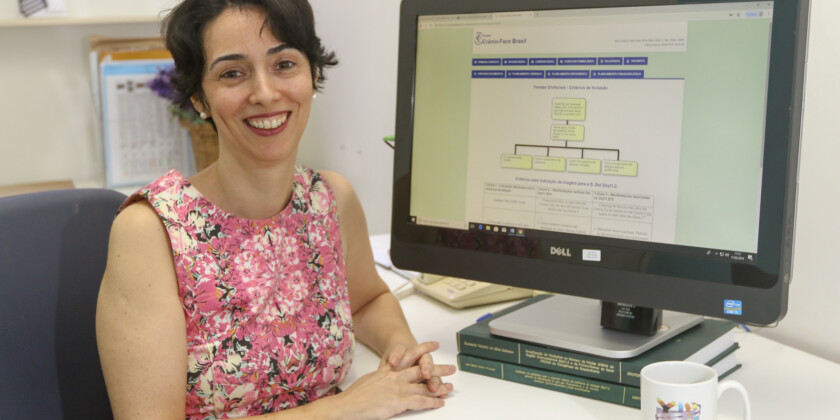 Prof. Vera Lúcia sentada em frente ao programa de computador