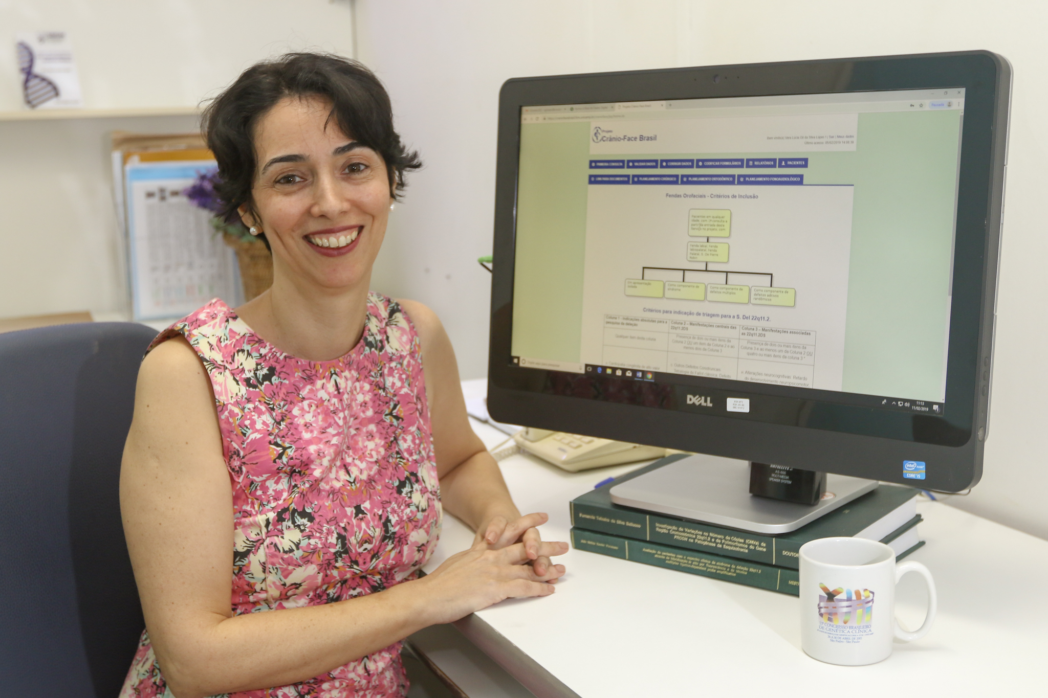 Prof. Vera Lúcia sentada em frente ao programa de computador