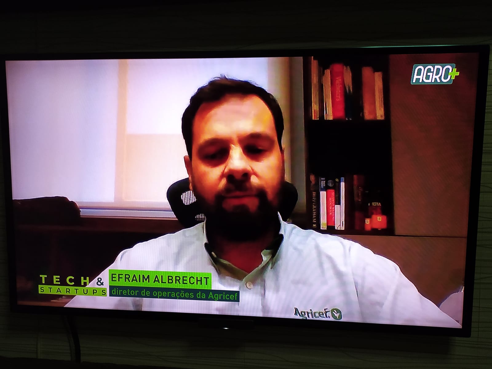 Na imagem está o diretor de operações da startup Agricef, Efraim Albrecht, em uma tela de televisão vestindo uma camisa polo na cor branca.