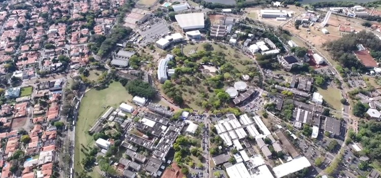 Foto aérea mostra prédios e praças da Unicamp. Fim da descrição