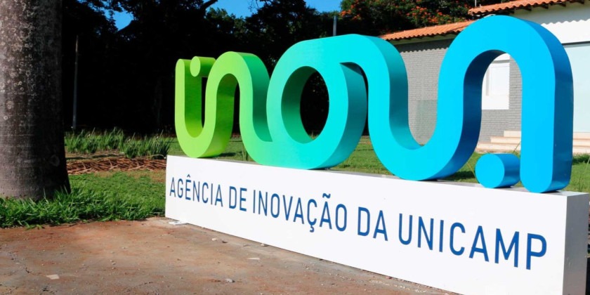 Monumento do Inova, escrito agência de inovação da Unicamp com uma casa ao fundo