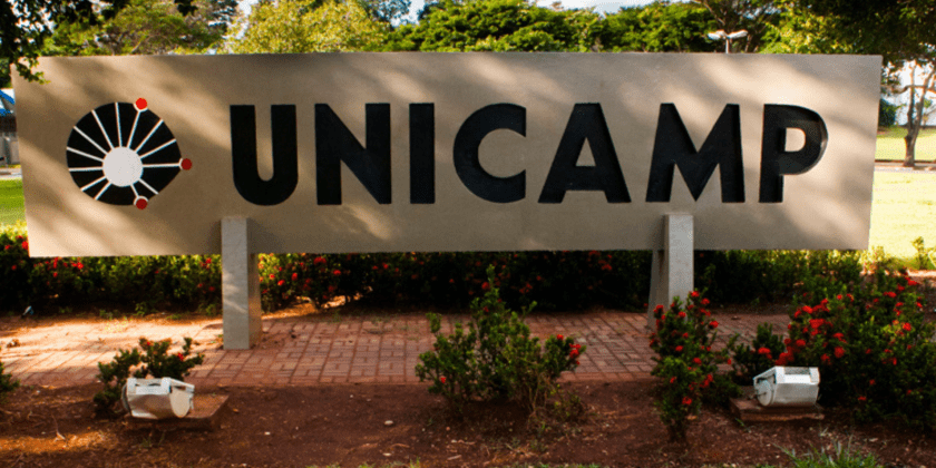 Totem com logotipo da Unicamp em praça. Fim da descrição